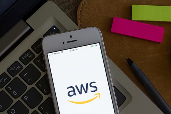 The AWS logo is displayed on a smartphone.