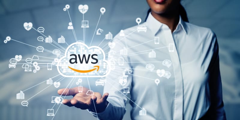 A female IT expert holding a virtual cloud with AWS text inscribed explains the path to become an AWS Cloud practioner.