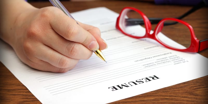 Close-up shot of a person filling a resume describes the professional resume preparation.
