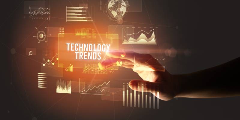 A human hand touching TECHNOLOGY TRENDS inscription on a virtual screen.