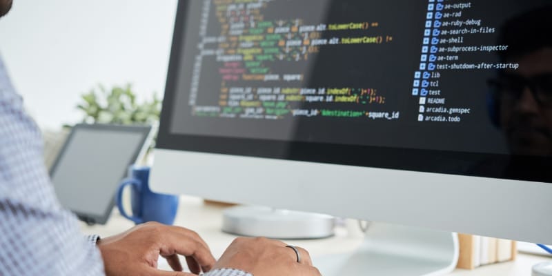 A young IT employee works on programming.